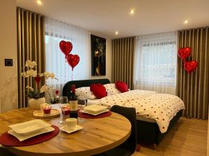 a bedroom with a bed and a table with red hearts at Apartamenty nad Starynką in Głuchołazy