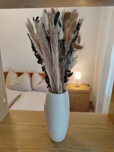 a white vase sitting on a table with flowers at Bergblick 33 in Plaus