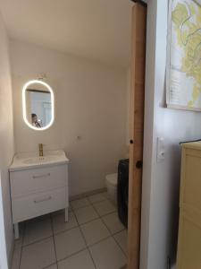 a bathroom with a sink and a mirror and a toilet at Location cocooning à Audenge in Audenge