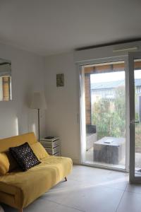 a living room with a couch and a large window at Location cocooning à Audenge in Audenge