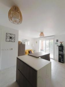 a kitchen with a island in a room at Location cocooning à Audenge in Audenge +14 photos