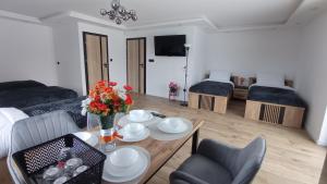 a living room with a table with flowers on it at Wakacyjna Pokusa in Kroczyce