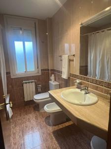 a bathroom with a sink and a toilet and a mirror at Hotel Berna - Valdeorras - Camino de Invierno in La Rúa