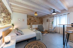 a bedroom with a bed and a stone wall at Sandoñana Old Palace Lodge in Villafufre