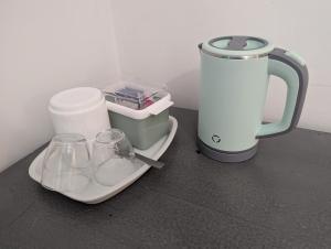 a tea kettle and two glasses on a counter at Le Tintamarre - Chambres et suite familiale à 5 min du Zoo de Beauval in Saint-Aignan +15 photos