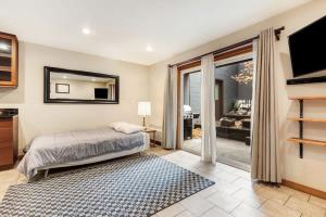 a bedroom with a bed and a flat screen tv at Ground level Condo near Downtown Bend in Bend