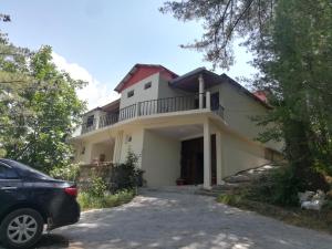 a house with a car parked in front of it at Basera Lodges in Nathia Gali