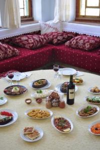 a table with plates of food and a bottle of wine at Old Greek House in Ürgüp