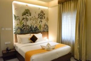 a hotel room with a bed with a flower on it at Hotel Muthahalli Grand in Bangalore +56 photos