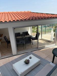 a patio with glass doors and a table and chairs at Casa Moinho Vedro in Quintiães