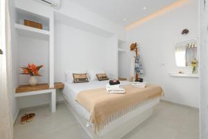 a white bedroom with a bed with towels on it at Anemomylos in Kastraki