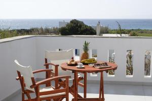 a table and chairs on a balcony with a view of the ocean at Anemomylos in Kastraki