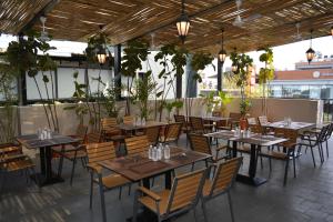 a restaurant with tables and chairs and potted plants at Hotel Muthahalli Grand in Bangalore