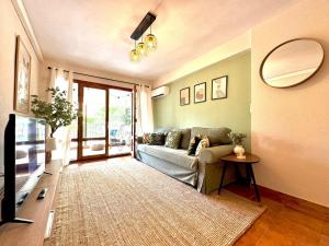 a living room with a couch and a mirror at La Palmera Suite Calpe in Calpe