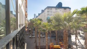 a view of a street with palm trees from a balcony at La Palmera Suite Calpe in Calpe