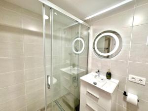 a bathroom with a shower and a sink and a mirror at La Palmera Suite Calpe in Calpe +10 photos