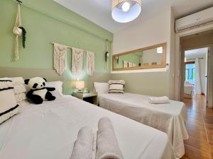 a bedroom with two beds with a teddy bear sitting on them at La Palmera Suite Calpe in Calpe