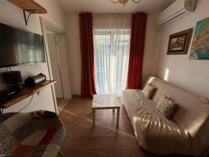a living room with a couch and a window at Sweet home with a jard Slavica in Šušanj
