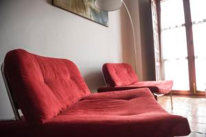 
a red couch sitting in a room next to a window at Alvaro de Torres Boutique in Úbeda
