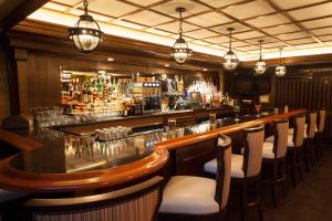 a bar with a long counter and chairs in a room at Historic Franklin Hotel in Deadwood