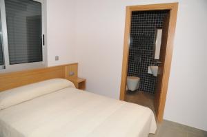 a bedroom with a bed and a bathroom with a shower at Apartamentos Bravosol in Denia