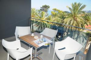 a balcony with a table and white chairs at Apartamentos Bravosol in Denia +13 photos