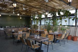 a restaurant with wooden tables and chairs and plants at Hotel Muthahalli Grand in Bangalore