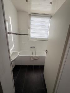 a bathroom with a tub and a sink and a window at A2 MonteurQuatier Lünen in Lünen