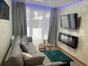 a living room with a couch and a fireplace at Mostique Spa Apartment with Jacuzzi in Gdańsk
