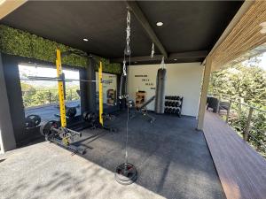 a gym with a bunch of equipment in a room at Roca Verde Retreats & Car Rental in Atenas