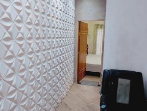a hallway with a white patterned wall in a room at pousada benção in Aparecida