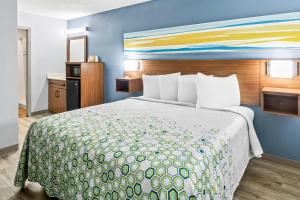 a bedroom with a large bed with a colorful bedspread at HomeTowne Studios by Red Roof Florence, KY-Cincinnati Airport in Florence +27 photos