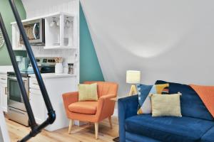 a living room with a blue couch and a chair at Old Rag Mountain Getaway - WiFi, Smart TV, Fire Pit, Patio, & Full Kitchen in Etlan