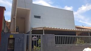 a white house with a fence in front of it at Kitnet Imigrantes in Holambra +2 photos