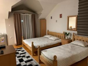 a bedroom with two beds and a desk and a mirror at Vila Sana in Landeke