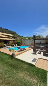 a backyard with a swimming pool and patio furniture at Casa Três Amores in Búzios
