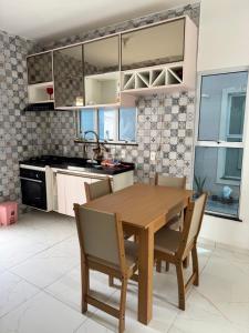a kitchen with a wooden table and chairs at Diamond Summer in Caucaia