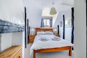 a bedroom with a large bed with white sheets at 2 Bed in Southwold oc-hdanby in Southwold
