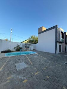 a swimming pool in a yard next to a building at Diamond Summer in Caucaia