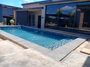 a swimming pool in front of a house at the Host at Bingos House Self Catering in Thohoyandou