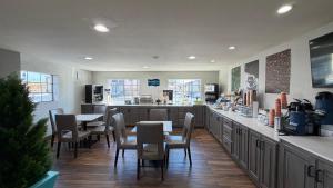 a kitchen with a table and chairs and a counter at Clarion Pointe Athens I-65 in Athens