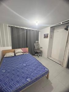 a bedroom with a bed and a chair in it at Alilonch Transient in Mangangbukol