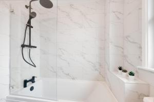 a white bathroom with a tub and a shower at 2 Bed in Braunton oc-stepco in Braunton +6 photos
