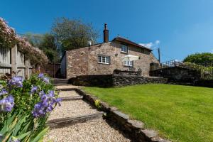 a stone house with purple flowers in front of it at 3 Bed in Berrynarbor oc-courtc in Berrynarbor