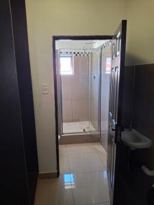 a bathroom with a shower and a sink at Silk Mbare Guest House in Manzini