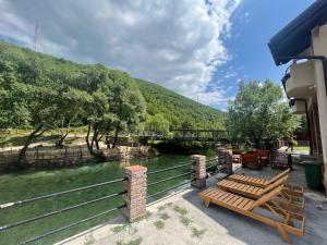 a couple of benches sitting next to a river at Vila Sana in Landeke