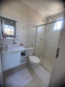 a bathroom with a toilet and a sink and a shower at Apê 250m da Orla de Piúma in Piúma +6 photos