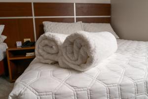 a bed with two towels on top of it at Hotel Benidorm Panama in Panama City