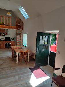 a living room with a table and a green door at Carrowkeel Cottage in Athlone +3 photos