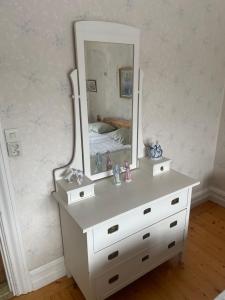 a white dresser with a mirror on top of it at Trunnagården in Orsa